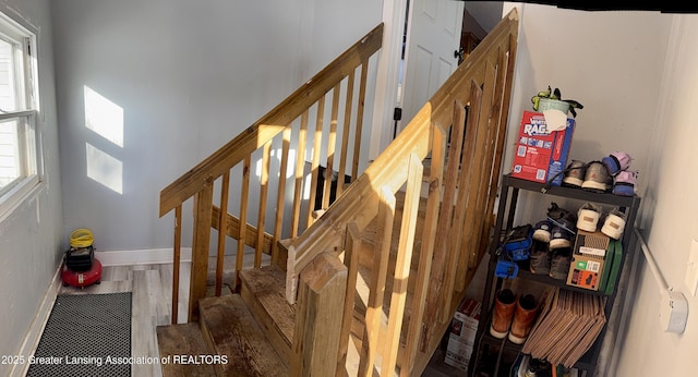 stairs with wood finished floors and baseboards