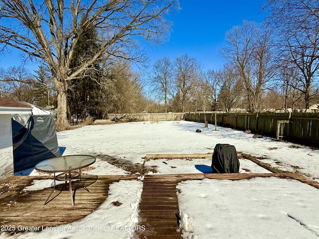 yard covered in snow with a fenced backyard