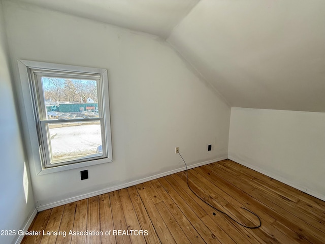 additional living space with lofted ceiling, wood-type flooring, and baseboards