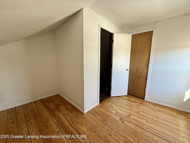 additional living space with lofted ceiling, baseboards, and hardwood / wood-style floors