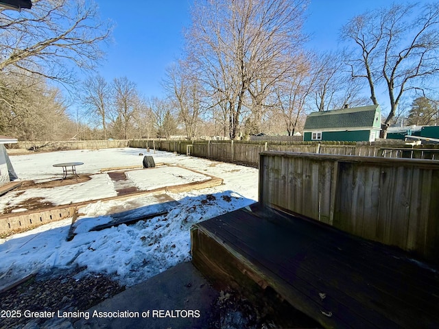 snowy yard with a fenced backyard