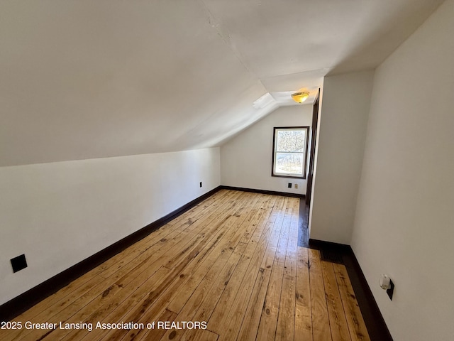 additional living space with baseboards, vaulted ceiling, and hardwood / wood-style floors