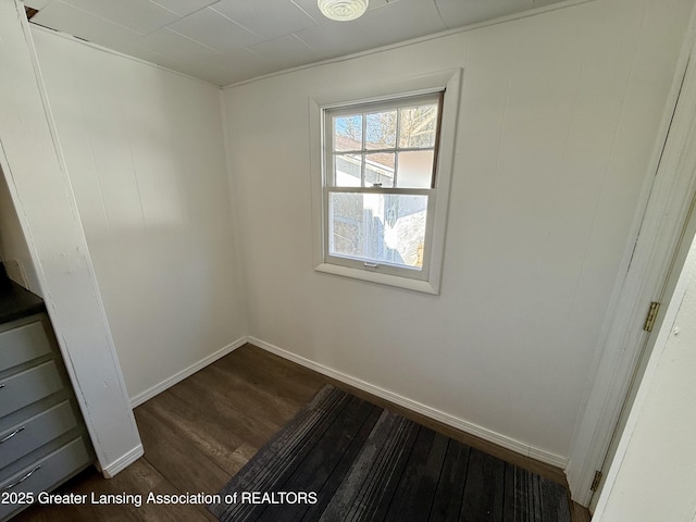 empty room featuring dark wood-type flooring and baseboards