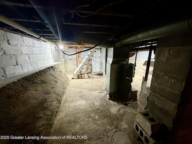 unfinished basement with washer and clothes dryer and heating unit