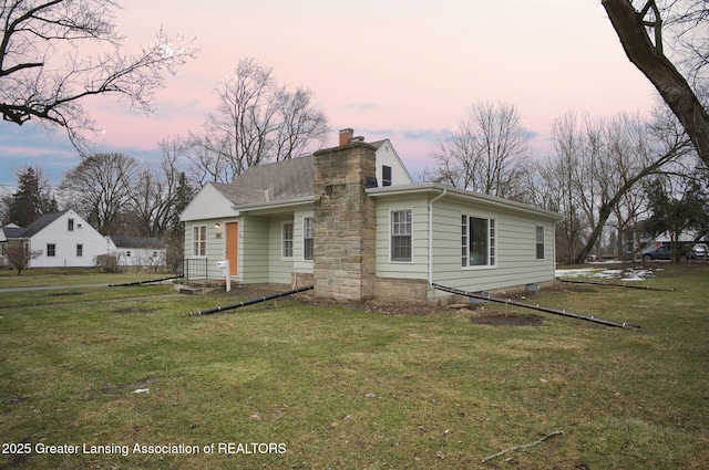 view of front facade featuring a yard and a chimney