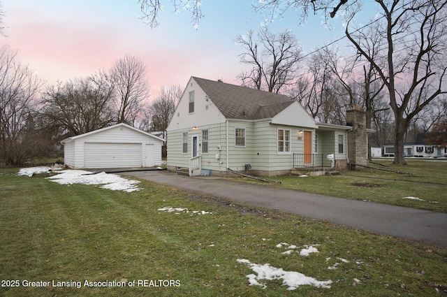 view of front of property featuring an outdoor structure, a detached garage, and a front lawn