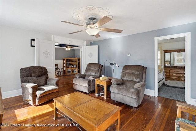 living room with ceiling fan, wood-type flooring, and baseboards