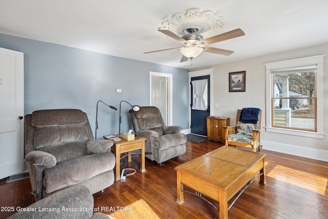 living room with a ceiling fan, baseboards, and hardwood / wood-style floors