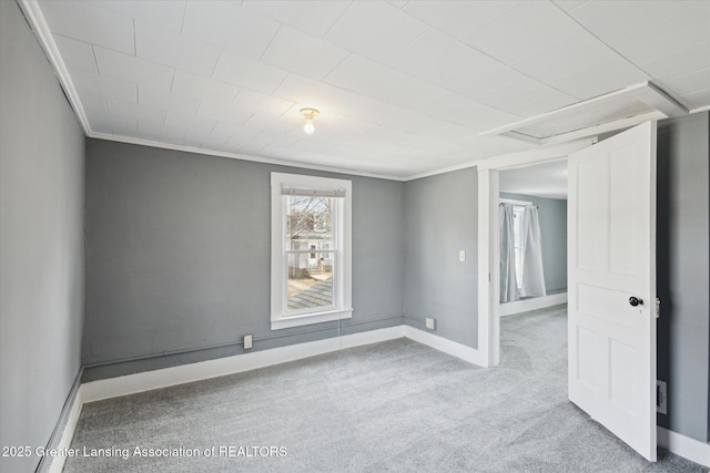 carpeted spare room with ornamental molding and baseboards