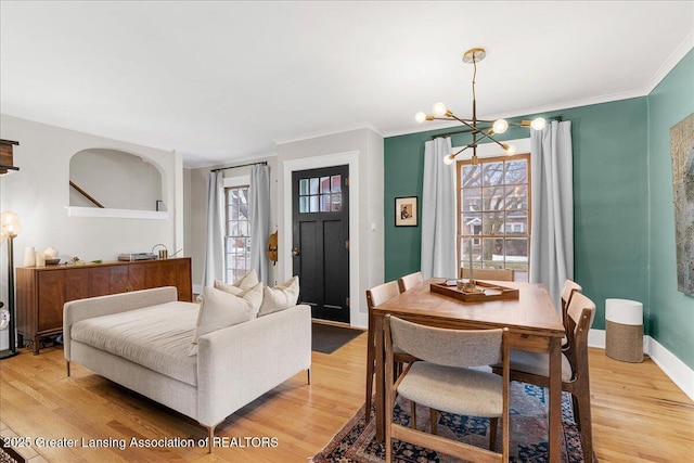 interior space with ornamental molding, light wood-type flooring, an inviting chandelier, and baseboards