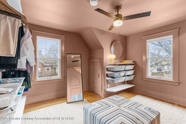 bedroom featuring lofted ceiling, light wood-style flooring, and baseboards