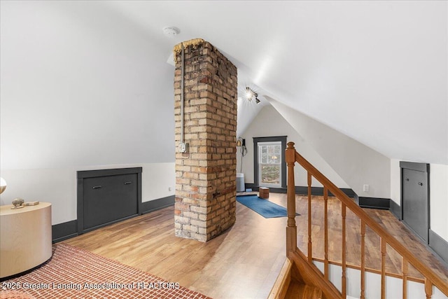 bonus room featuring lofted ceiling, baseboards, and wood finished floors