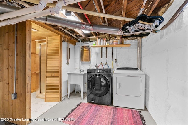 clothes washing area featuring laundry area, a sink, and washer and dryer