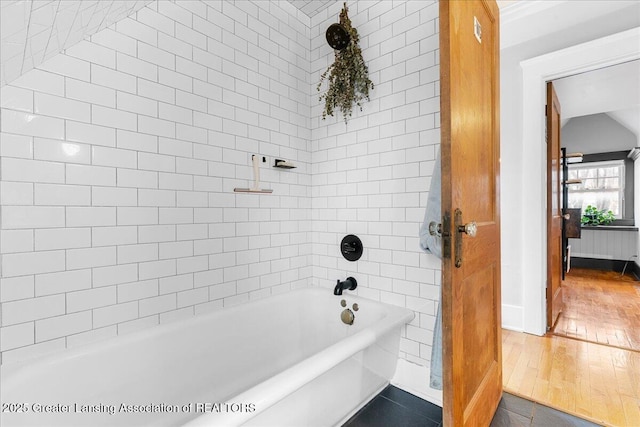 full bathroom featuring lofted ceiling, a tub to relax in, and wood-type flooring