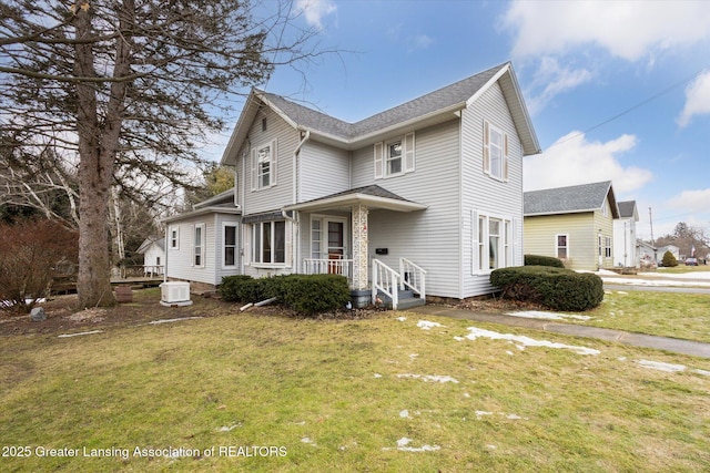 traditional home featuring central AC and a front yard