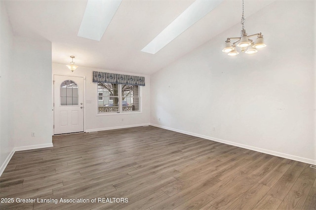 interior space with lofted ceiling with skylight, wood finished floors, and baseboards