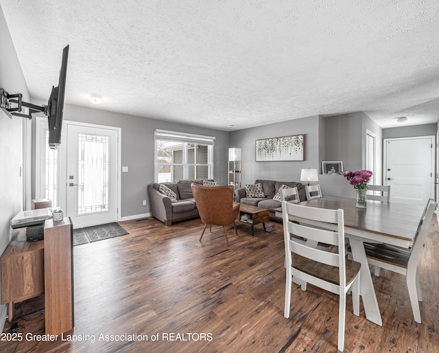 dining space featuring a textured ceiling, baseboards, and wood finished floors