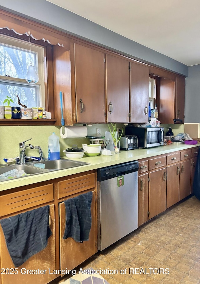 kitchen with stainless steel appliances, a sink, and light countertops