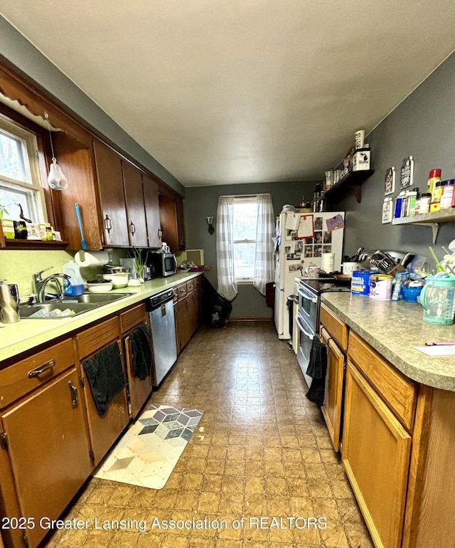 kitchen featuring brown cabinets, light floors, stainless steel appliances, light countertops, and a sink