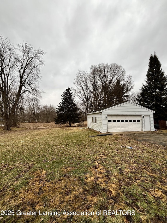 view of yard featuring a garage and an outbuilding