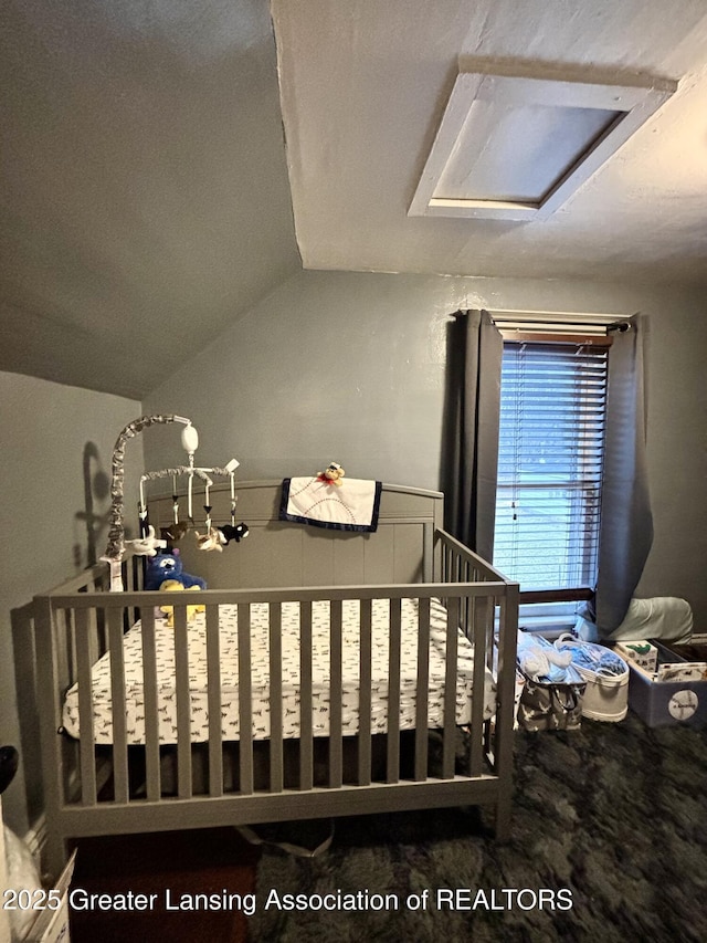 bedroom featuring vaulted ceiling and attic access