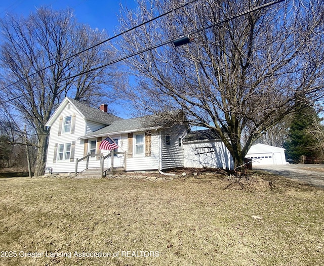 view of front of house featuring a garage, roof with shingles, and a chimney