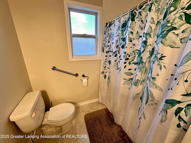 full bathroom with a shower with shower curtain, toilet, and baseboards