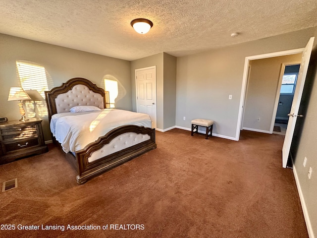 bedroom featuring baseboards, visible vents, dark carpet, and a textured ceiling