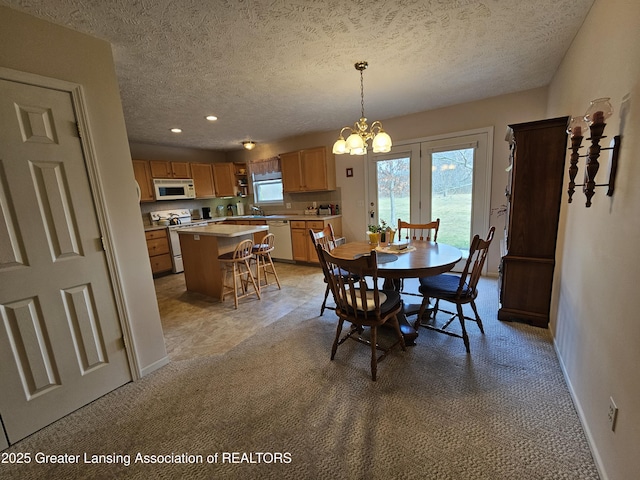 dining room featuring recessed lighting, light colored carpet, a textured ceiling, a chandelier, and baseboards