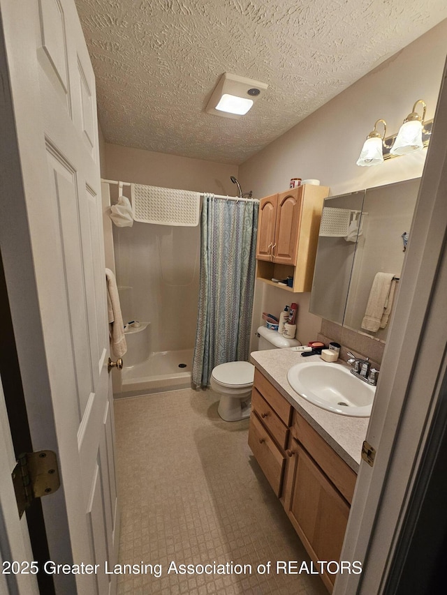 full bath featuring a textured ceiling, vanity, a shower stall, and toilet