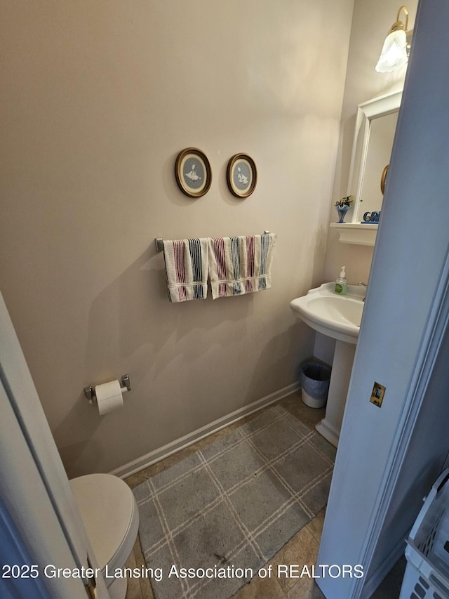 half bath with toilet and baseboards