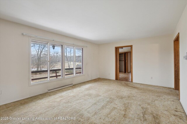 carpeted spare room featuring baseboard heating