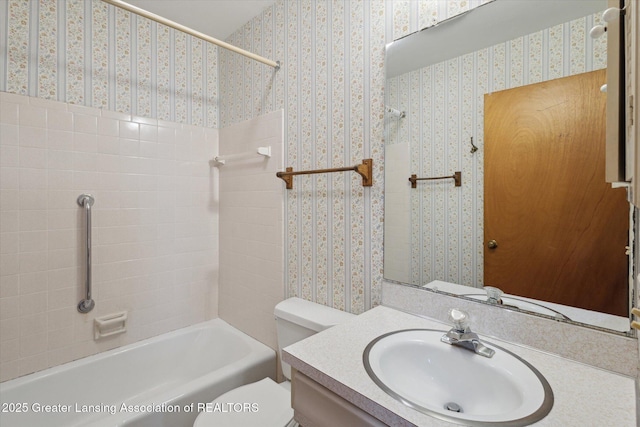 full bath with washtub / shower combination, vanity, toilet, and wallpapered walls