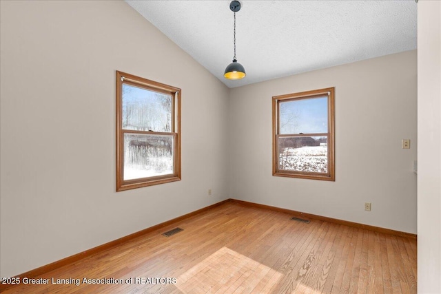 spare room with plenty of natural light, visible vents, and light wood-style floors