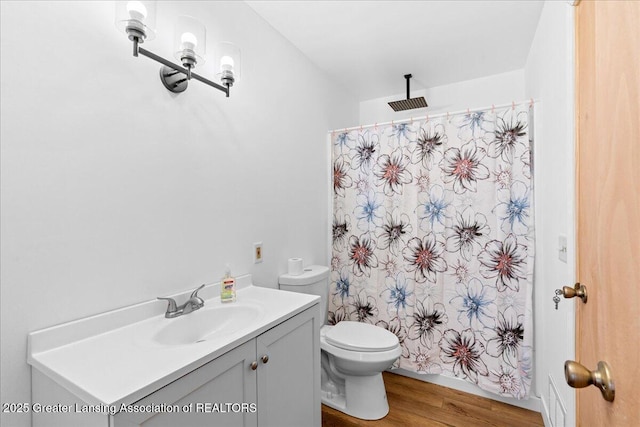 bathroom with curtained shower, vanity, toilet, and wood finished floors