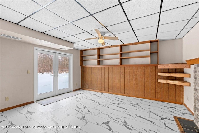 interior space featuring a paneled ceiling, visible vents, baseboards, marble finish floor, and french doors