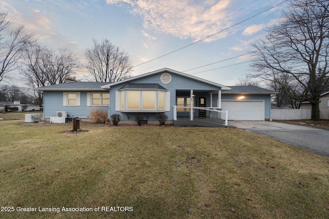 ranch-style house with aphalt driveway, covered porch, fence, a garage, and a front lawn