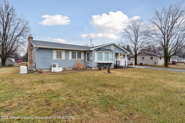 view of front of house featuring driveway, a shingled roof, a chimney, and a front lawn