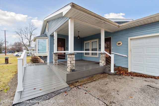 doorway to property with covered porch and an attached garage