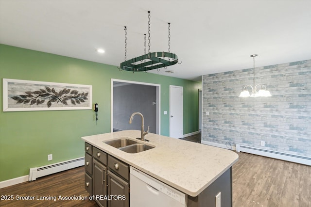 kitchen featuring an accent wall, white dishwasher, a sink, and baseboard heating