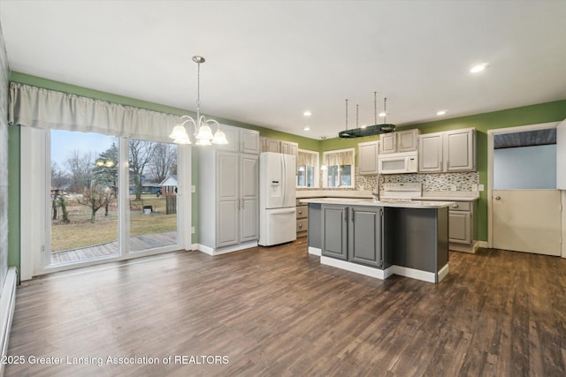 kitchen with dark wood finished floors, light countertops, backsplash, gray cabinetry, and white appliances