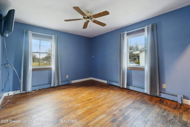 spare room with a baseboard radiator, baseboards, ceiling fan, and hardwood / wood-style floors