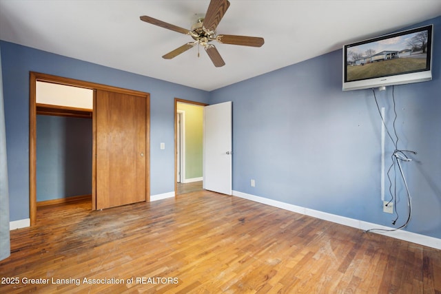 unfurnished bedroom with light wood finished floors, ceiling fan, baseboards, and a closet