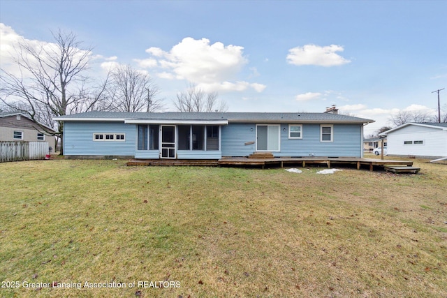 rear view of property with a sunroom, a chimney, a deck, and a lawn