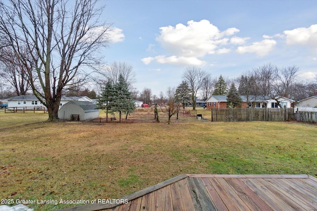 view of yard with a shed, an outdoor structure, fence, and a residential view