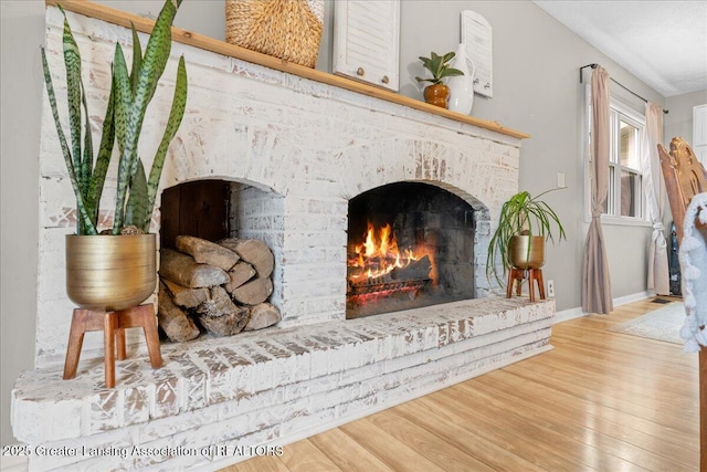 interior details featuring a fireplace, baseboards, and wood finished floors