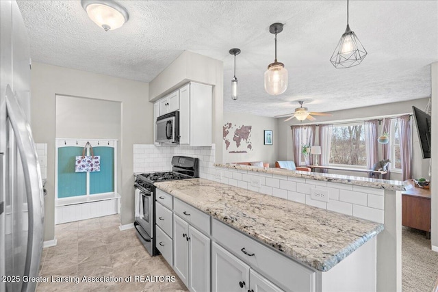 kitchen featuring appliances with stainless steel finishes, decorative light fixtures, a peninsula, white cabinetry, and backsplash