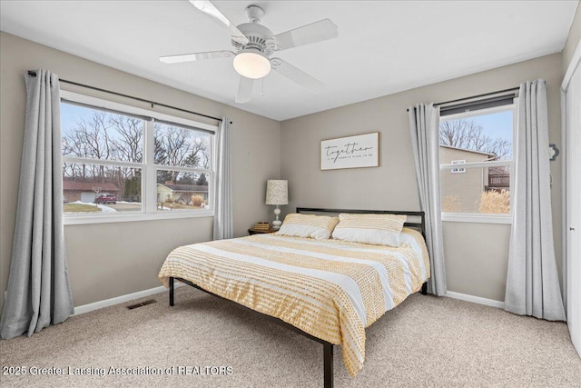 carpeted bedroom with ceiling fan, visible vents, and baseboards