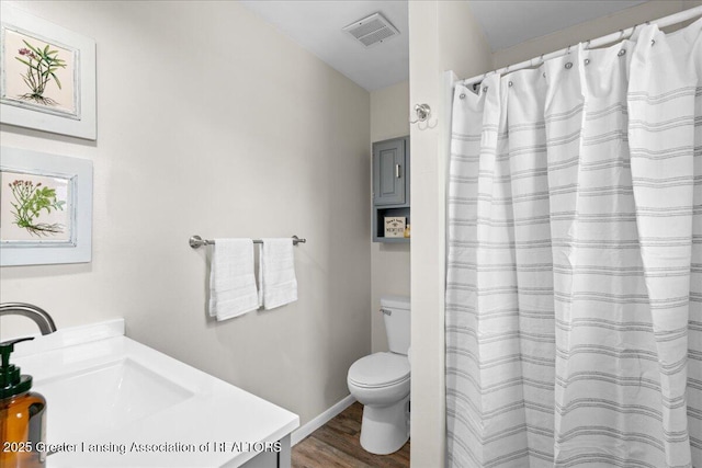 full bathroom with toilet, a shower with shower curtain, wood finished floors, vanity, and visible vents