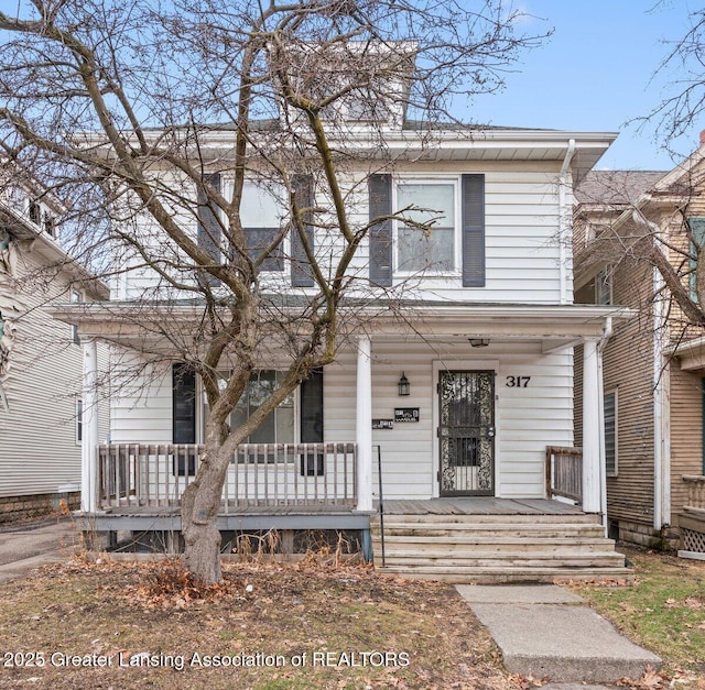 american foursquare style home featuring covered porch